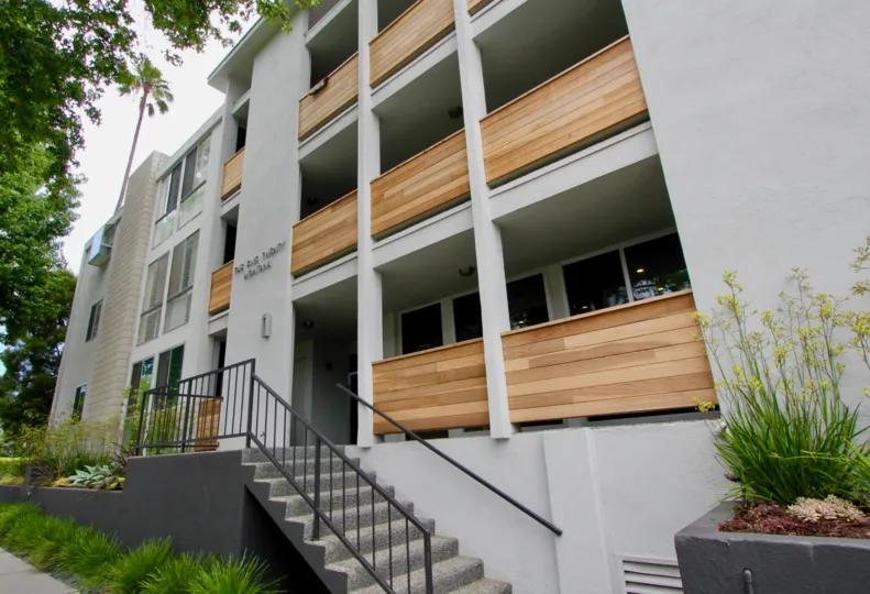 A white building in the Santa Monica Terrace community with wooden balconies