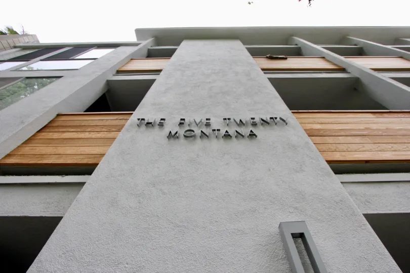 The Five Twenty Montana of Santa Monica, California towers in the foreground of an upshot. Wooden balconies accent the stone architecture.