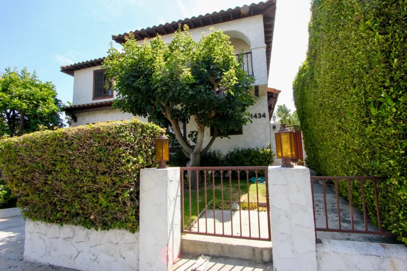 The sun hangs over a home with a gated fence in the Santa Monica Villas.