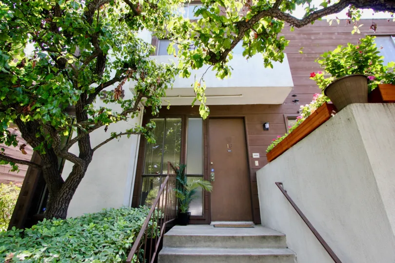 A bright day in the Seabreeze Townhomes with an entrance and trees.