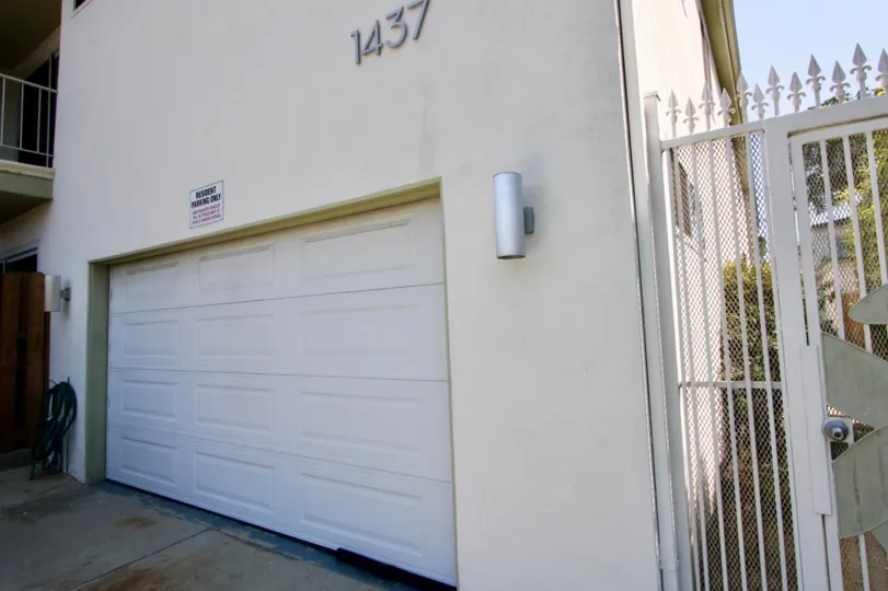 A white house in the Stanford Street Apartments community with a single white garage door