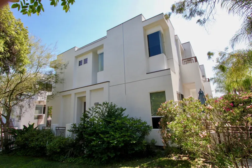 The Sunset Park Villas with white color and number of trees and plants around