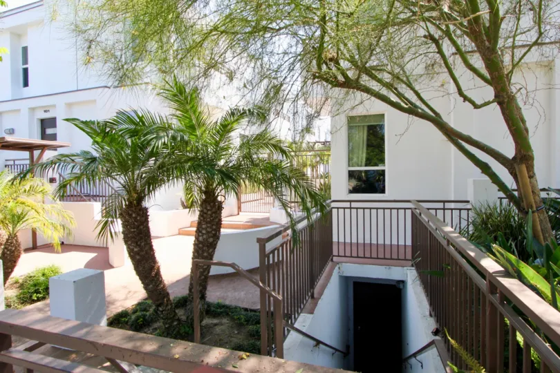 The Sunset Park Villas with large trees in front side