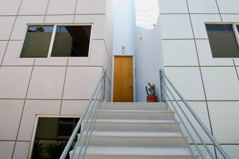 Entry of a big white building in santa monica with brown door