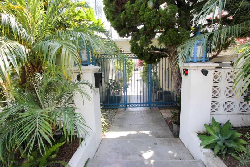 A blue gate entrance with shrubbery at The Mediterranean in Santa Monica, CA
