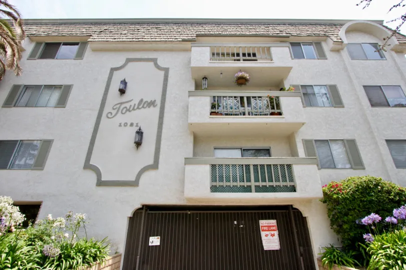 A beautiful day in the Toulon Gardens with an apartment and sign.