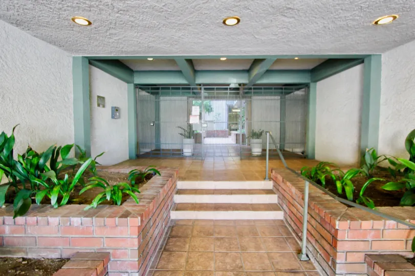 Villa Centinela ceramic and stucco entry with green painted beams and columns in Santa Monica California