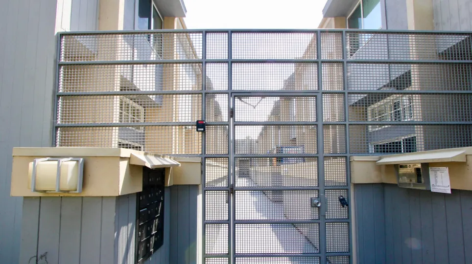 A bright day in the Villa La Mesa with a metal gate.