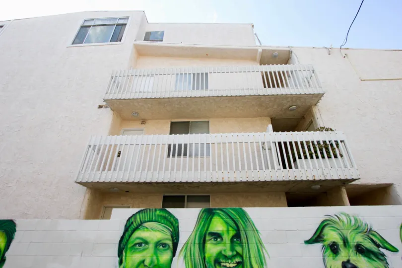 Green portraits below white balconies on a sunny day at the Navy Estates