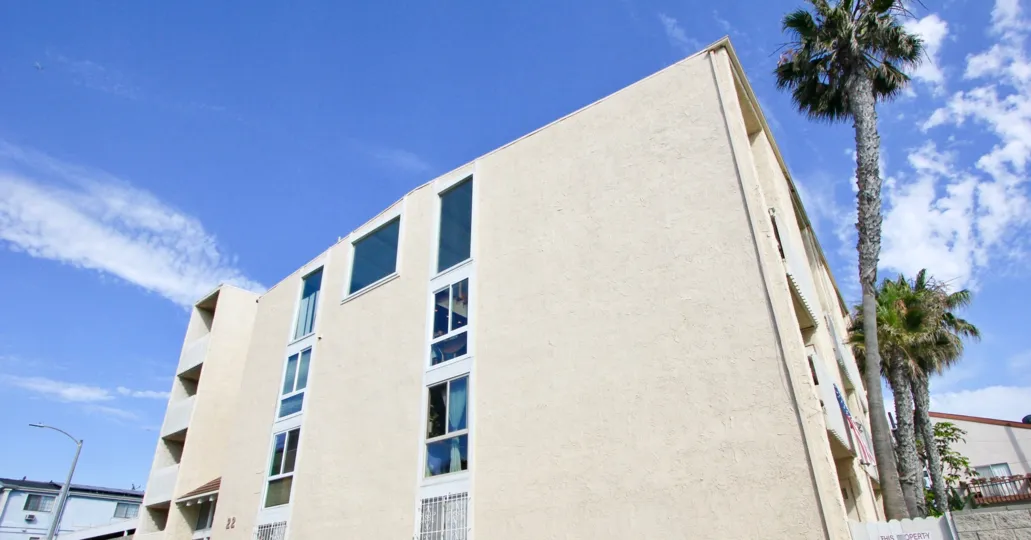 A sunny day at the Navy Estates Apartments with trees and light poll