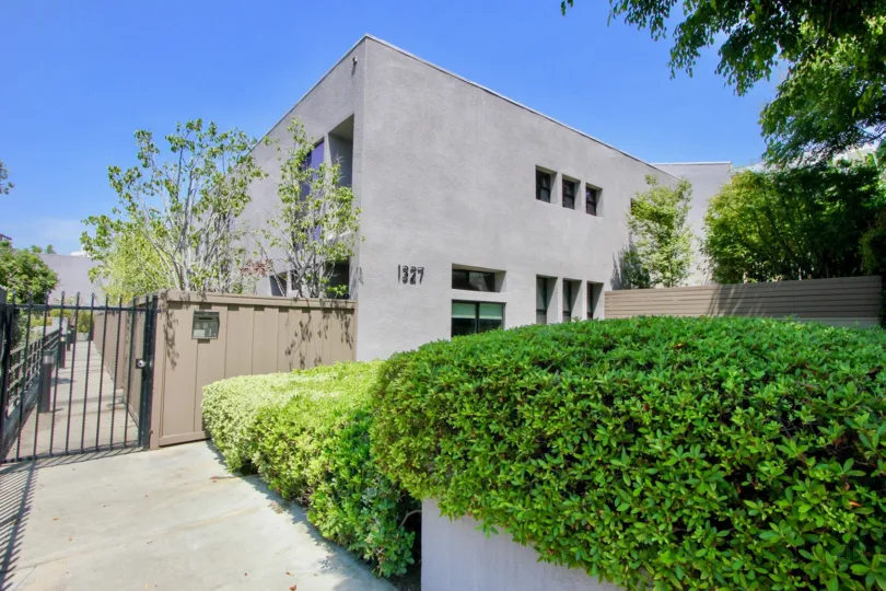 A sunny day in the Doheny Villas with beautiful apartment and big tree infrond of apartment.