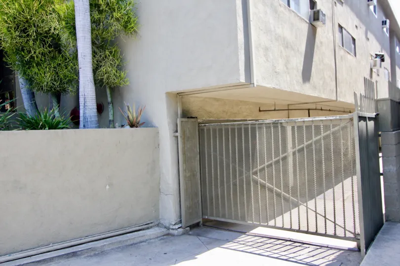 A white building at 938 Palm with a white fence and palm trees
