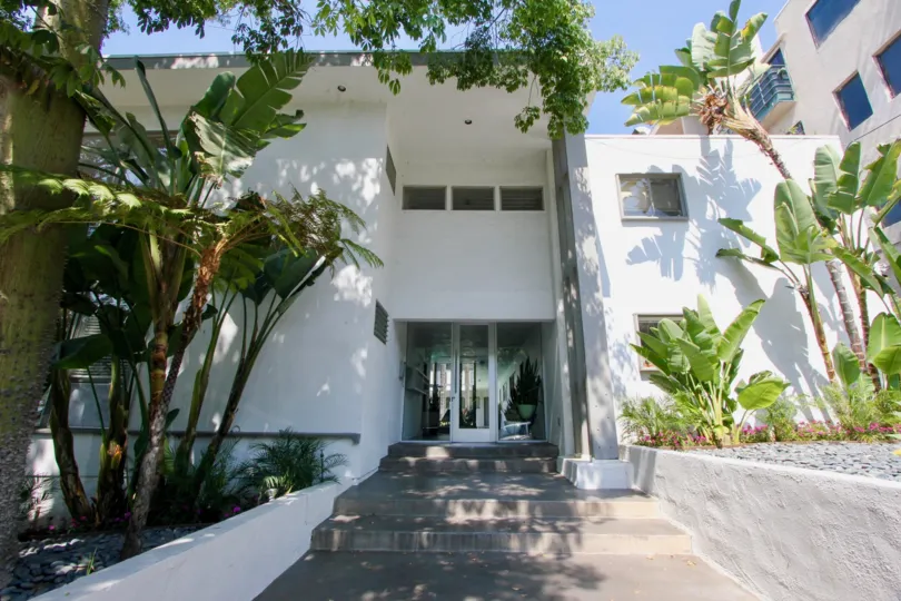 A lovely day at The Larrabee Villas, a concrete residence with a modern garden and trees on the property.
