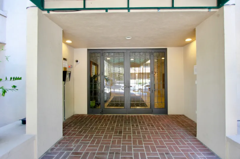 A white building in the Palm Hancock neighborhood with a glass front door and red brick floor
