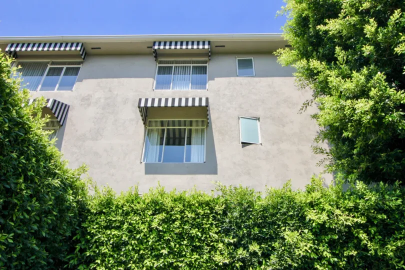 A sunny day at Sunset Plaza Terrace, with verdant hedges and stucco-style apartments