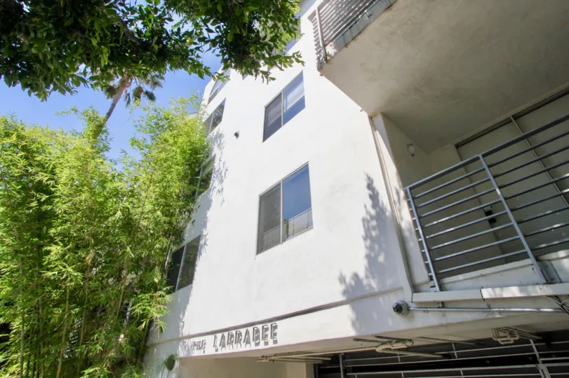 a white building in The Larrabee with trees in the front