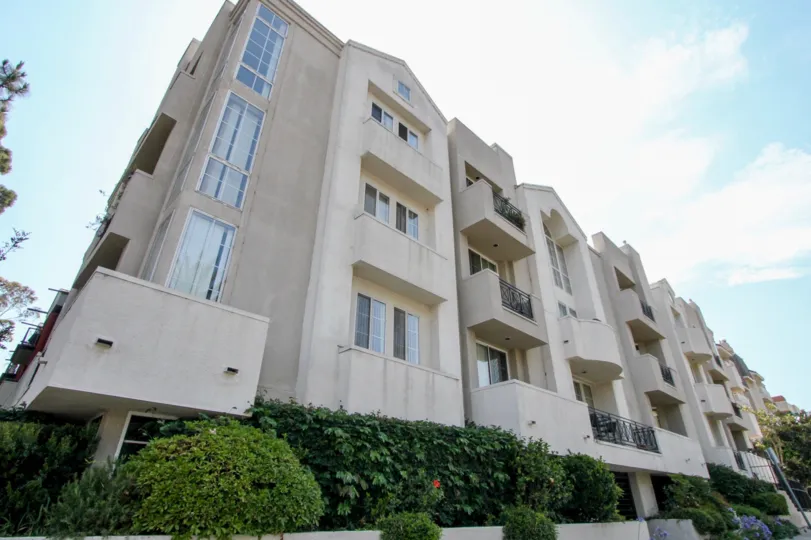 A LARGE SIZE APARTMENTS WITH BALCONY AND WINDOWS THE SKY ALSO LOOKING HOT SOME PLANTS NEAR TO THE HOUSE
