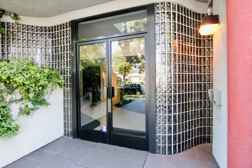 the front door of a building in 12211 Idaho with plants at the side