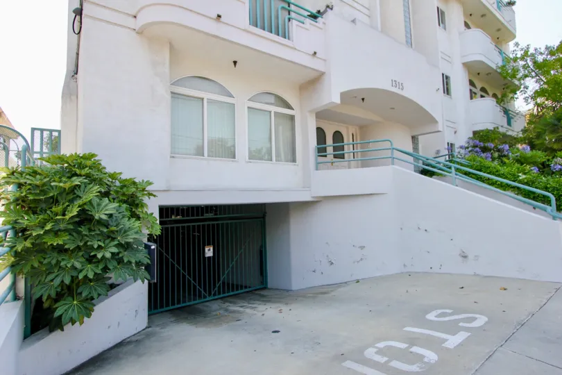 A white house at 1315 Saltair with light blue railings and a single gated garage