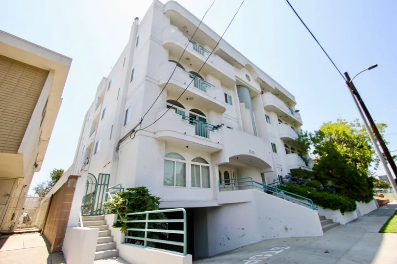 A white multifamily housing facility with green railings in the 1315 Saltair community of West LA, California.