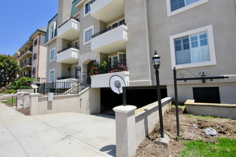 A sunny day in a lovely, well-maintained apartment complex in Colby, West LA with flower boxes and ornate lamps.