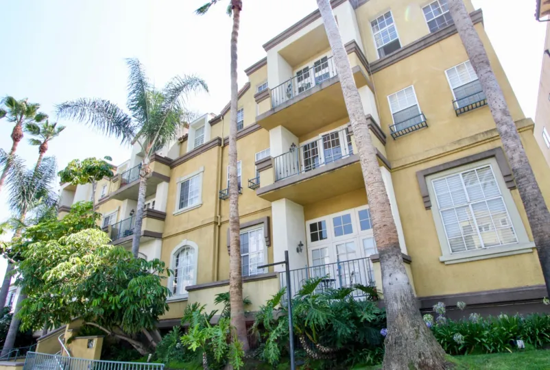 A sunny day in the Armacost Fountains with beautiful apartment and big tree infrond of apartment.