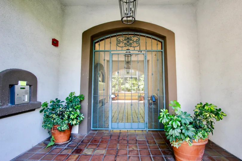 Front gate, plants, and intercom at Armacost Fountains in West LA, California