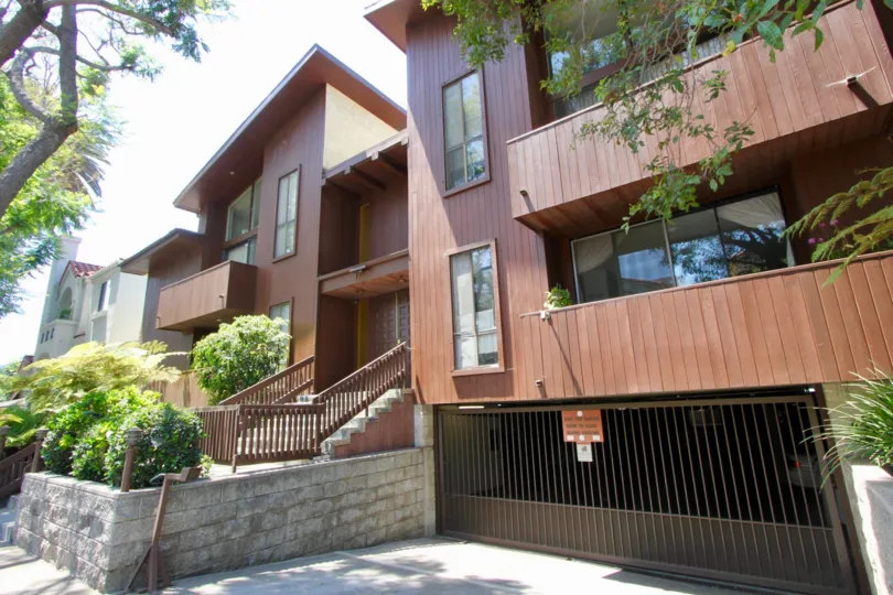 Wooden exterior with garden underground garage and tree lined street with trimmed hedges