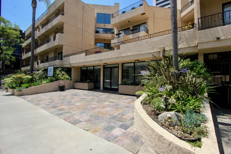 Grand entrance to the concrete apartment building and gardens as well