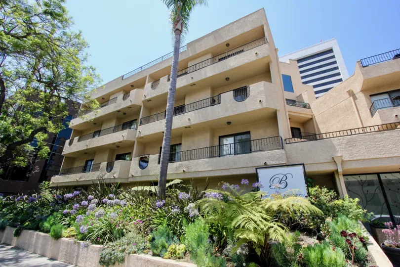 A tan apartment building with landscaping in the Bentley Regency community