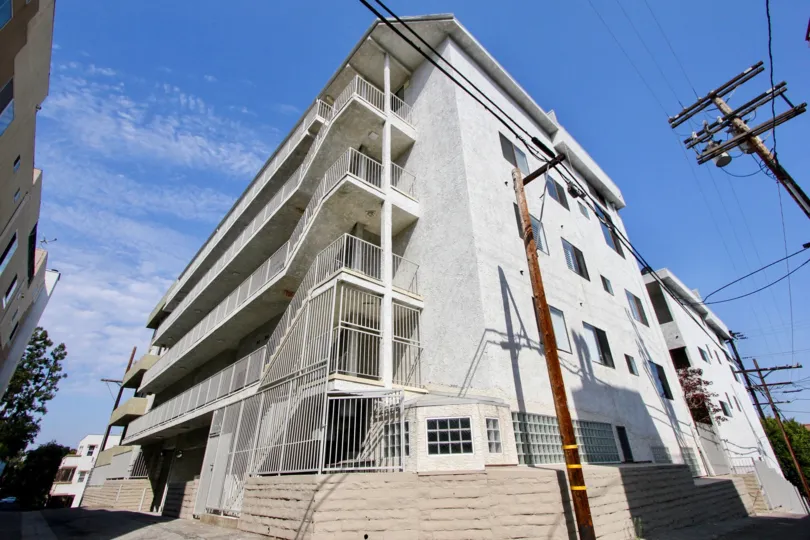 two post electric wire is in front of house and sunny day and sky in blue color