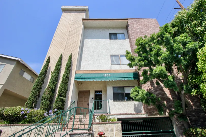 Brockton Chateau, 1258 A beautiful sky high well construct building which have elegant colour and shiny bright glass windows. Lots of green trees enhance its beauty. A sunny bright day give it an amazing look.