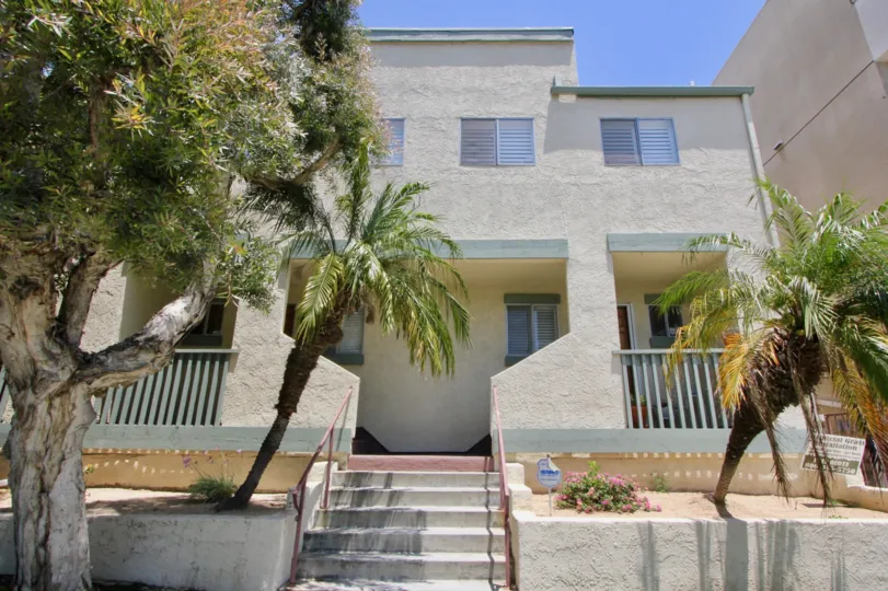 Stucco lined Townhomes with pam trees and sandy non-water garden in west LA