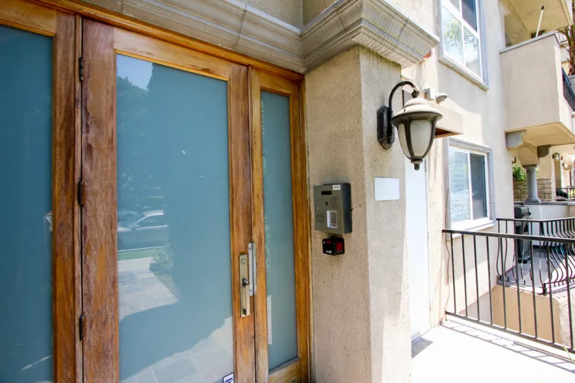 A gated doorway with frosted glass and rustic door handles and side lamps