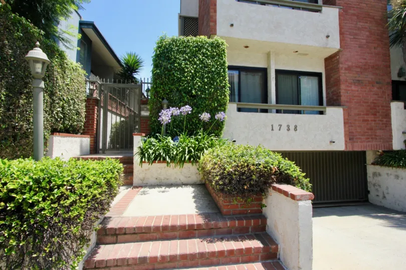 Beautiful planted and cone shaped flower at the staircase entrance of A brick decorated House at Chateau West in in West LA California
