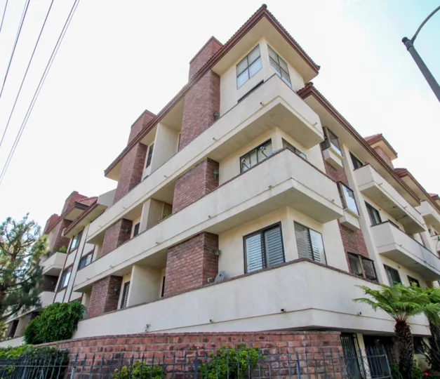 house constructed with brick contains three floors and each flor contains two or more dish antenna and light sunny day