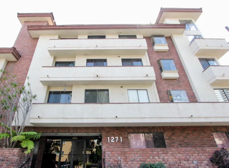 Straight shot of 1271 Granville Gardens Apartment with it brick and creamy styled walls, West La, California
