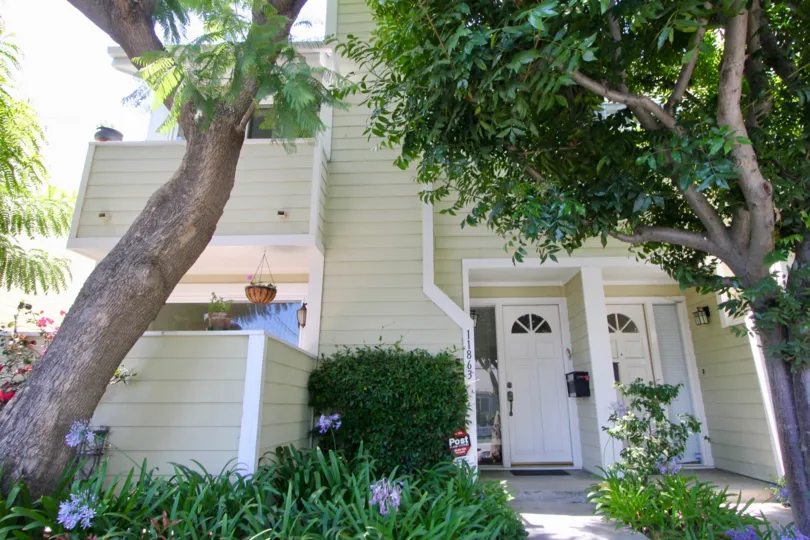 shaded entry way with two doors beneath trees at Nebraska Manor Townhomes