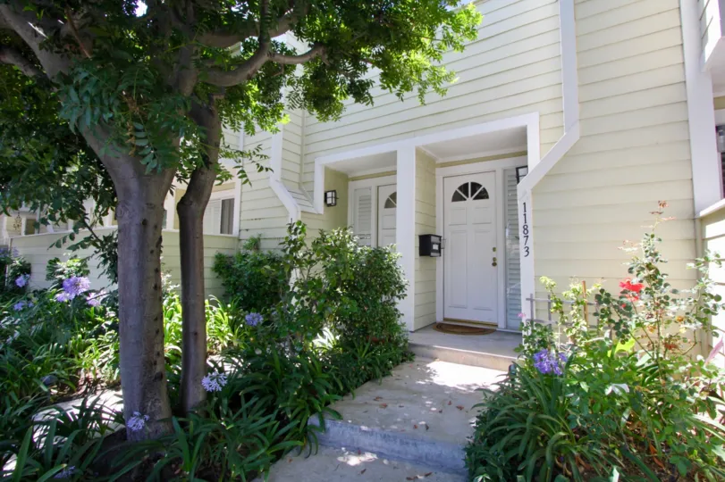 A sunny day in the Nebraska Manor Townhomes Townhomes a beautiful house and trees.