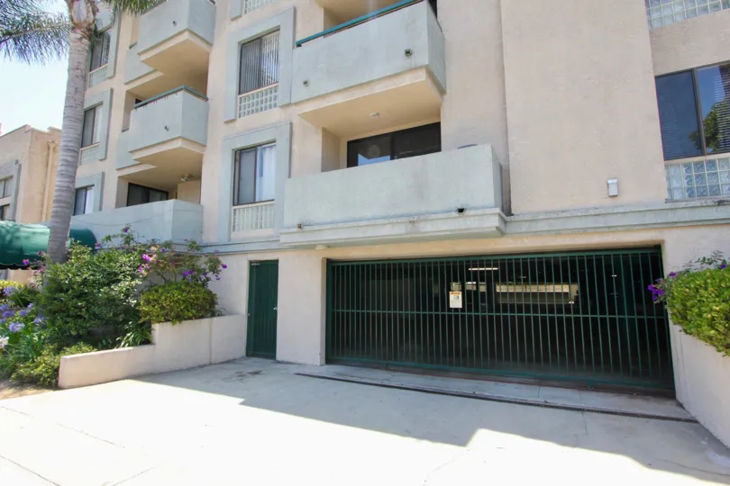 garage entrance area with flowers and palm trees planted for beauty