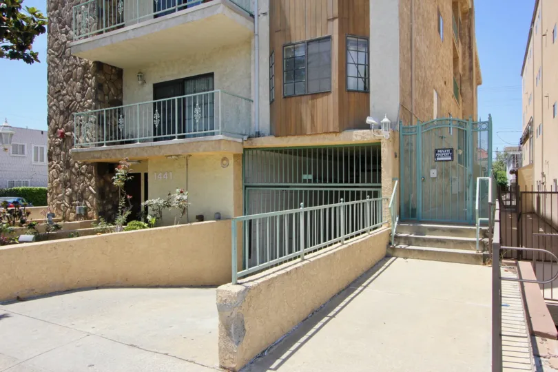 Underground parking area with fences and rocky wood stucco outside area on the building
