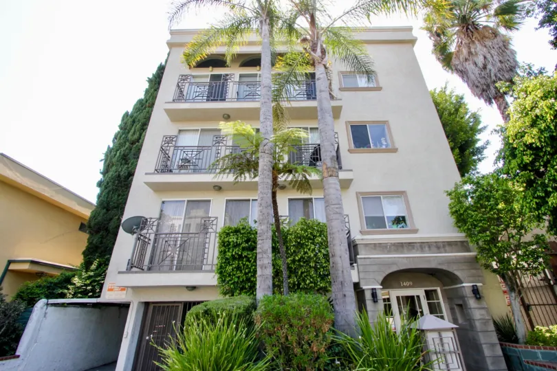 Narrow apartment home with entrance of gardens and palm trees with underground garage
