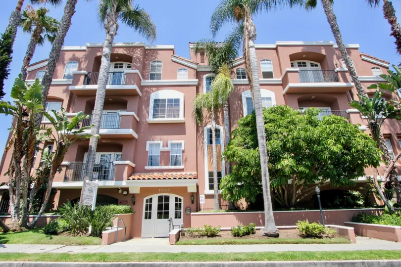 A sunny day in the Villa Rose Townhomes a beautiful house and trees.