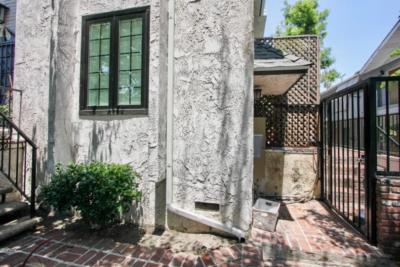 beautiful dark grey condo with green bush and black fence in los angeles california