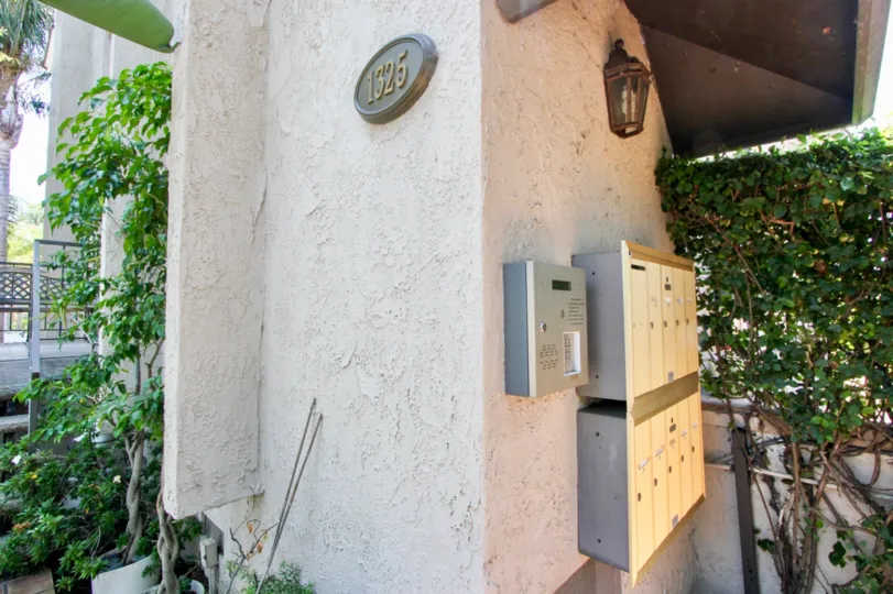 Green plants planted round A brown colored building at Wellesley west in in West LA California and with the House number 1325