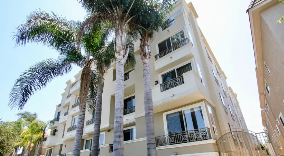 A sunny day in the West Wing Grand Plaza Townhomes a beautiful house and trees.