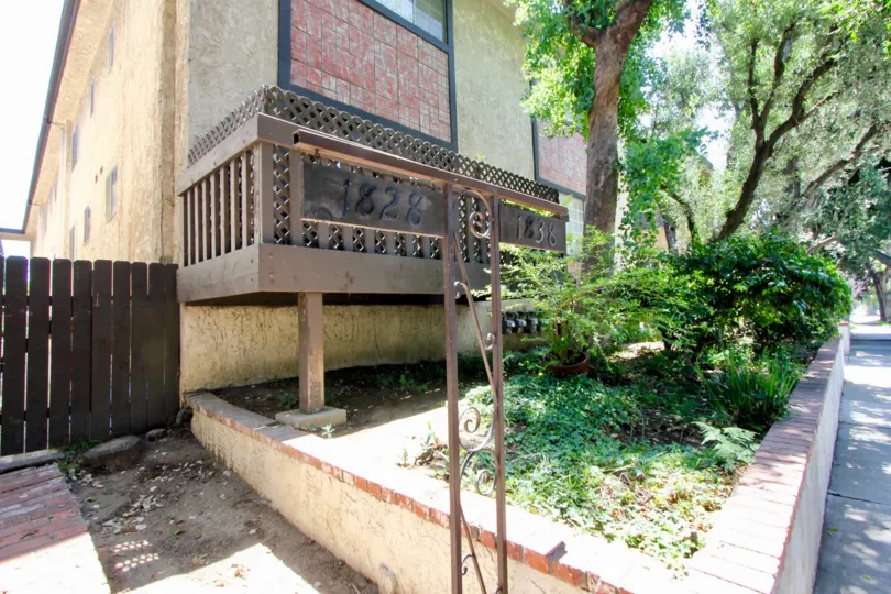 an arbor and back alley entrance along the sidewalk
