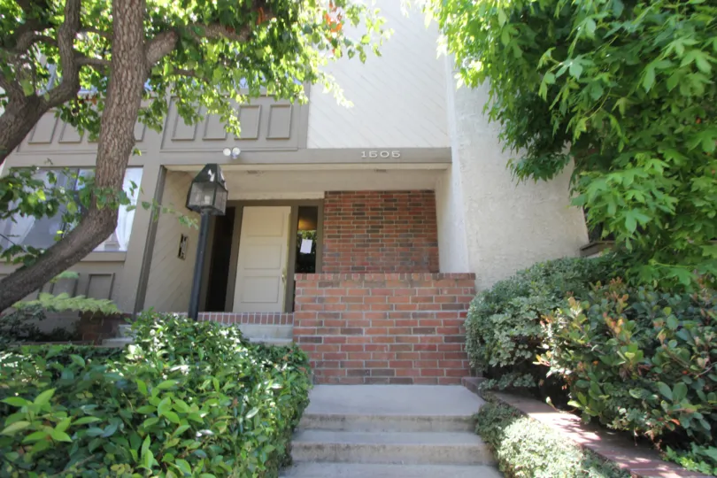 Shrubs are maintained and landscaped in front of this brick home with steps leading up to front door