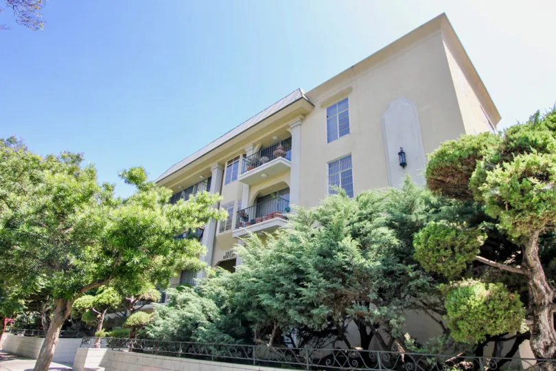 Outside of 1410 Bentley. Greenery lines the walkway directly outside of the building.
