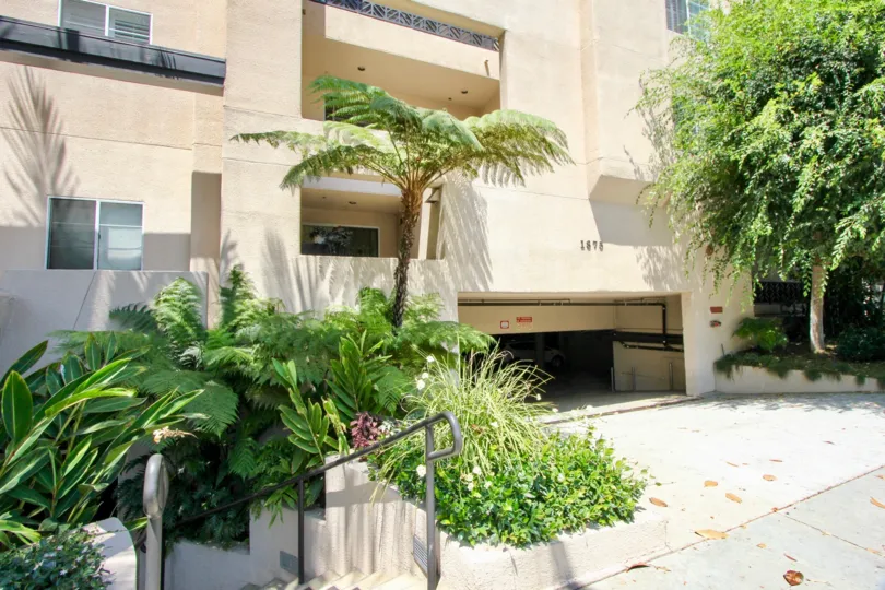 1875 Beverly Glen building with green trees. Underground car parking also shown in the picture. Glass windows looks glossy and bright in sun shine.